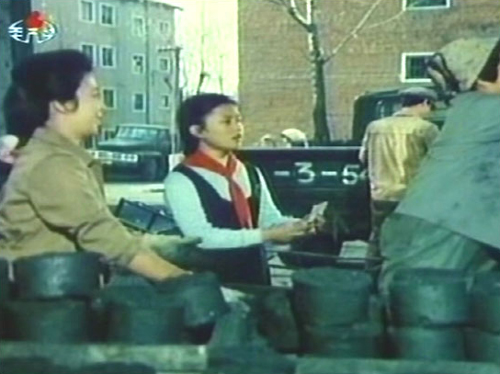 北朝鮮映画「心に残る人」の一シーン。練炭の配給を受け取る女子学生。