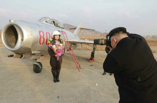 北朝鮮初の女性追撃飛行士を撮影する金正恩氏
