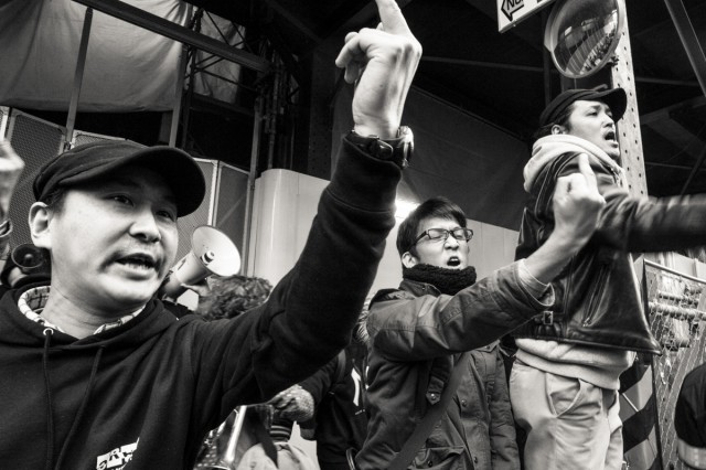 2014年3月、池袋で行われたヘイトデモに中指を建てて抗議しているカウンター参加者　（撮影：島崎ろでぃ）