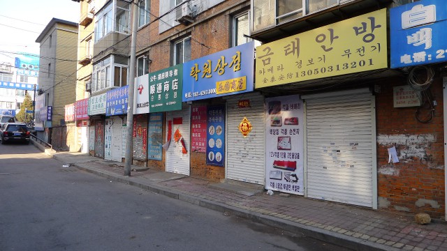 朝鮮語の看板を掲げた商店が立ち並ぶ丹東税関そばの前進街