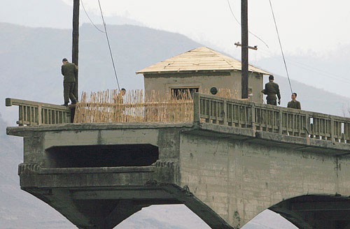 爆撃で破壊された橋で記念撮影をする中国人観光客。北朝鮮の国境警備隊は、観光客の増加に対応するために大型の警備哨所を建設した。（画像：デイリーNK）