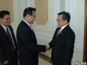 北朝鮮の朴明国外務次官（中央）と握手する中国の劉振民外務次官