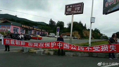 中国政府の突然の禁輸令に抗議して、圏河税関の前で「制裁するなら中国国民が損害を被らないように保護せよ」との横断幕を掲げる人々（画像：大力視角