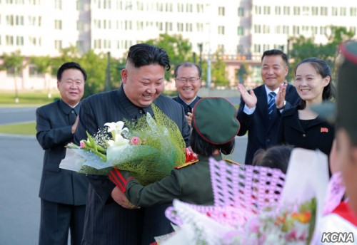 朝鮮少年団第8回大会参加者から花束を受け取る金正恩氏。右端が金与正氏。（2017年6月8日付朝鮮中央通信より）
