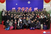 海外作戦部隊将兵の家族らと記念写真を撮った金正恩氏（2026年1月1日付朝鮮中央通信）